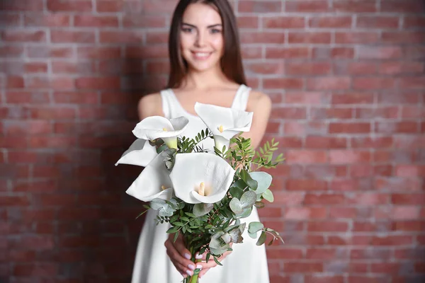 Krásná mladá žena držení kytice — Stock fotografie