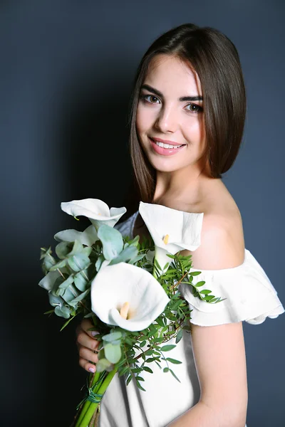 Beautiful young woman holding bouquet — Stock Photo, Image