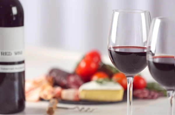 Glasses of red wine with food — Stock Photo, Image