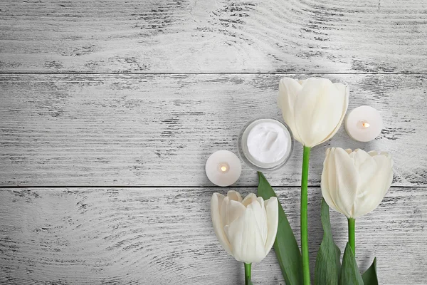 Cosmetische crème met tulpen — Stockfoto