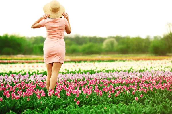 Mujer en campo floreciente de tulipanes — Foto de Stock