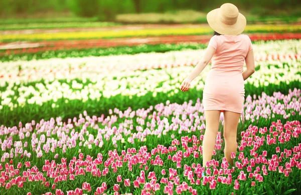 Vrouw op bloeiende gebied van tulpen — Stockfoto