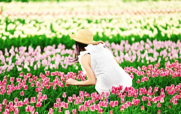 Mujer en campo floreciente de tulipanes —  Fotos de Stock