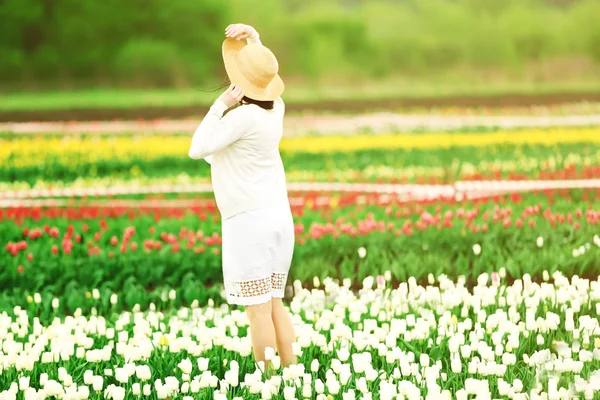 Mujer en campo floreciente de tulipanes —  Fotos de Stock