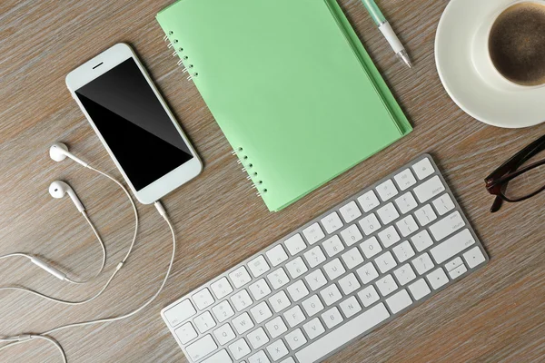 Teclado, telefone, notebook e xícara de café — Fotografia de Stock