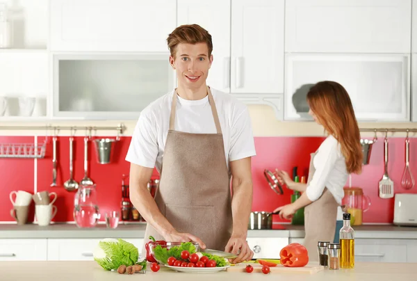 Casal em aventais cozinhar — Fotografia de Stock