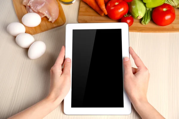 Woman reading recipe from tablet