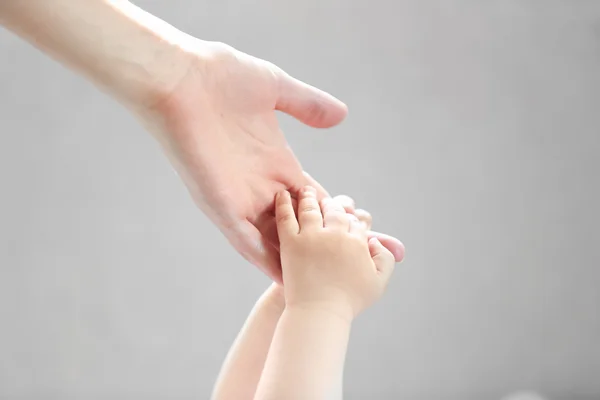 Kvinna anläggning liten bebis hand — Stockfoto