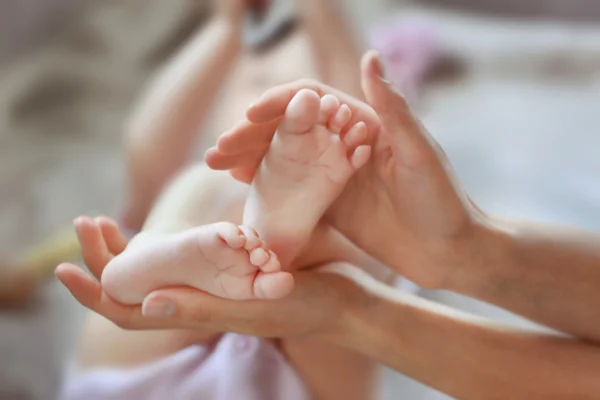 Nő gazdaság kis baba lábát — Stock Fotó