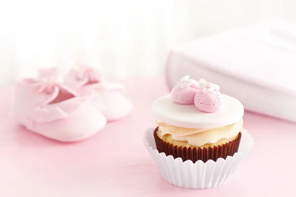 Leckere Cupcake und Babyschuhe — Stockfoto