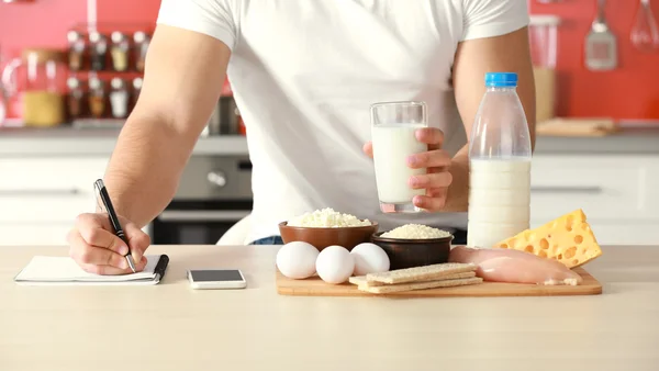 Homme comptant les calories sur la table — Photo