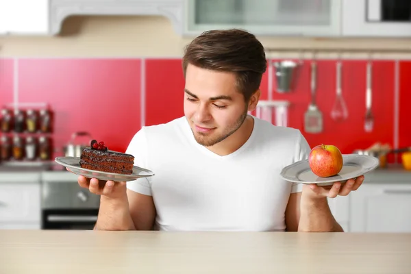 Hombre con comida sana y malsana — Foto de Stock