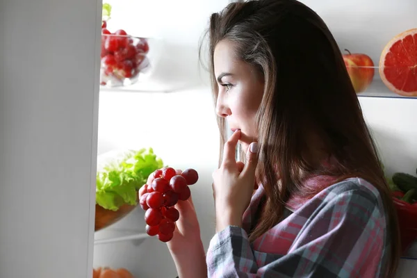 Frau schaut nachts in Kühlschrank — Stockfoto