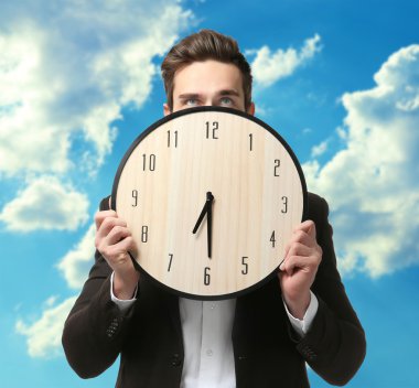 Büyük saat tutan siyah elbiseli adam 