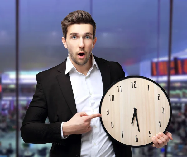 Homem de terno preto segurando relógio grande — Fotografia de Stock