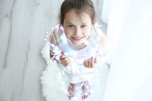 Klein meisje in lichte garland — Stockfoto
