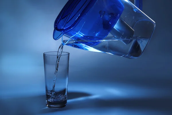 Filterkrug gießt Wasser ins Glas — Stockfoto