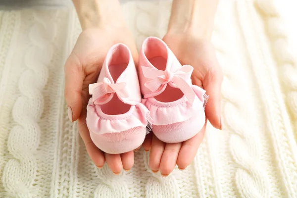 Woman holding baby booties — Stock Photo, Image