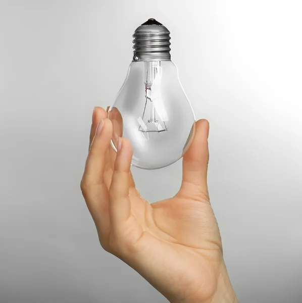 Mulher mão segurando lâmpada — Fotografia de Stock