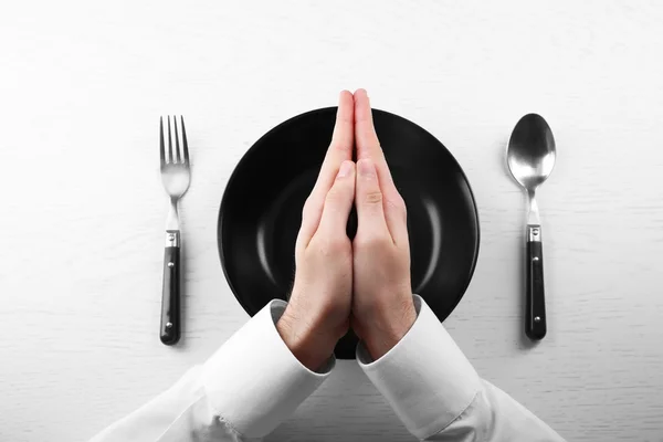 Man holding hands over empty plate. — Stock Photo, Image