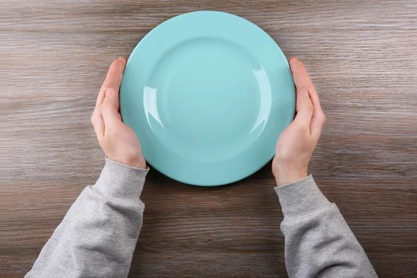 Man holding empty plate. — Stock Photo, Image