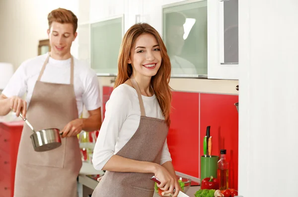 Couple dans tabliers cuisine dans la cuisine — Photo