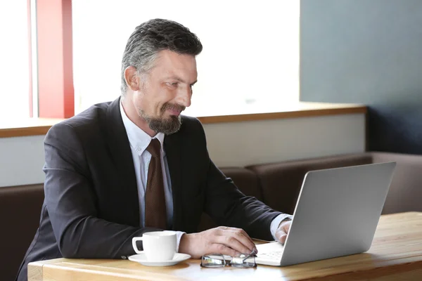 Uomo d'affari con computer portatile in caffè — Foto Stock