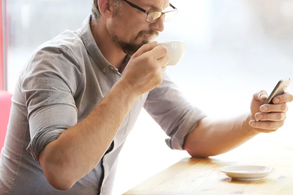 Empresario con celular y taza de café — Foto de Stock