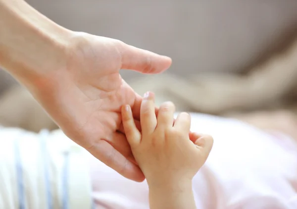 Frau hält kleine Babyhand — Stockfoto