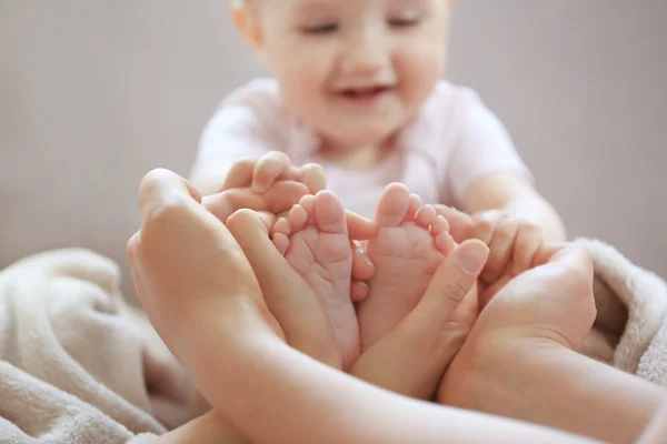 Kvinna anläggning liten baby fötter — Stockfoto