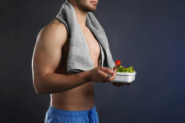 Giovane uomo con cibo sano su sfondo scuro — Foto Stock