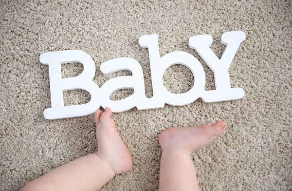 Patas de bebé y palabra decorativa — Foto de Stock