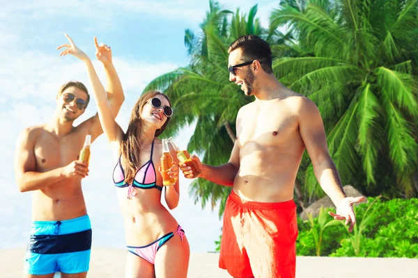 Des amis heureux buvant de la bière à la plage — Photo