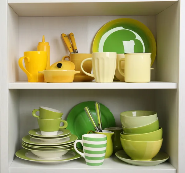 Tableware on shelves in cupboard