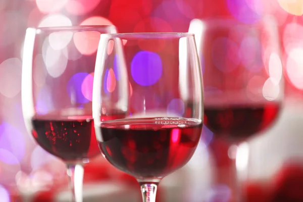 Bicchieri da vino su luci rosse sfocate — Foto Stock