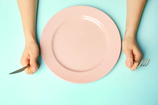 Женские руки со столовыми приборами и пустой тарелкой — стоковое фото