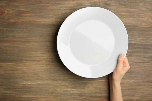 Женская рука и пустая тарелка — стоковое фото