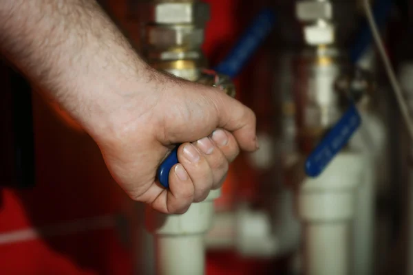 Human hand starting heating system up — Stock Photo, Image