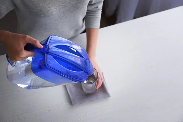 Woman pouring filtered water — Stock Photo, Image