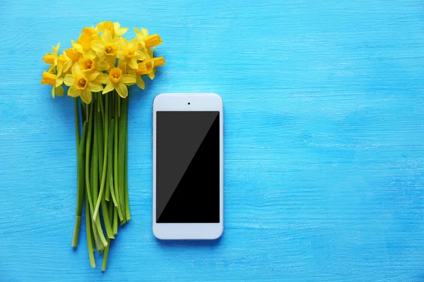 Gelbe Narzissen und Smartphone — Stockfoto