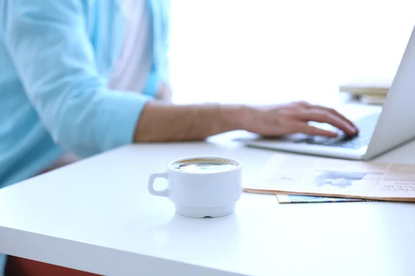 White cup of coffee and man working — Stock Photo, Image