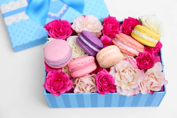 Tasty macaroons and roses in box — Stock Photo, Image