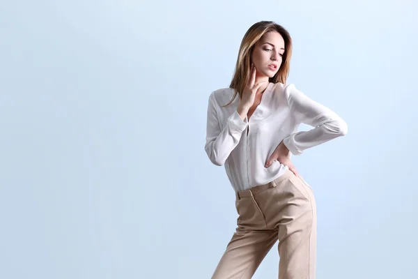 Vrouw in een wit overhemd en een beige broek — Stockfoto