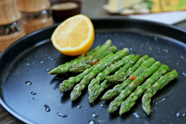 Asparagus with lemon on plate — Stock Photo, Image