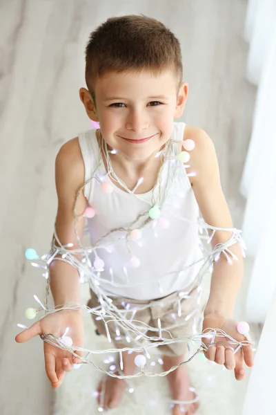 Jongetje in lichte garland — Stockfoto