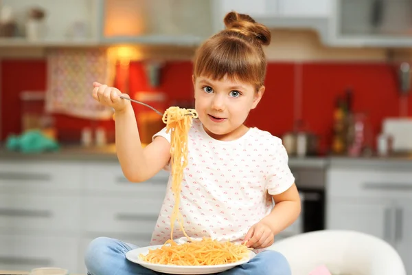 Bedårande liten flicka äter spaghetti — Stockfoto
