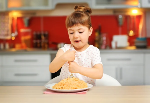 Adorable little girl eating spaghetti