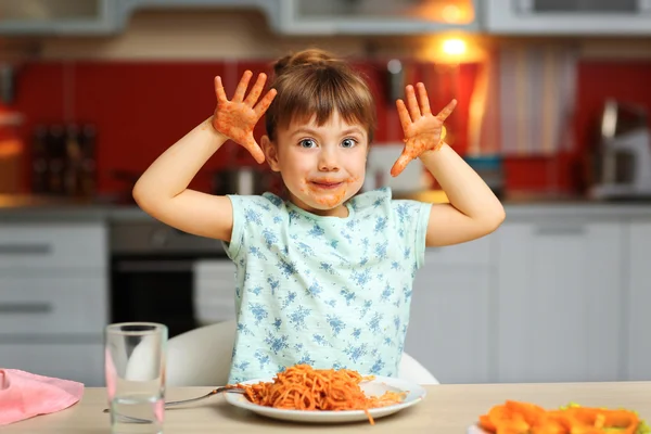 Очаровательная девочка ест спагетти — стоковое фото