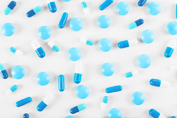 Niebieskie tabletki na tle — Zdjęcie stockowe