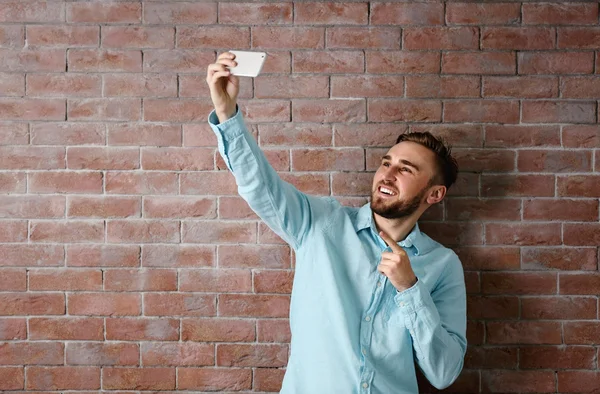 Człowiek biorąc selfie na tle ściany — Zdjęcie stockowe